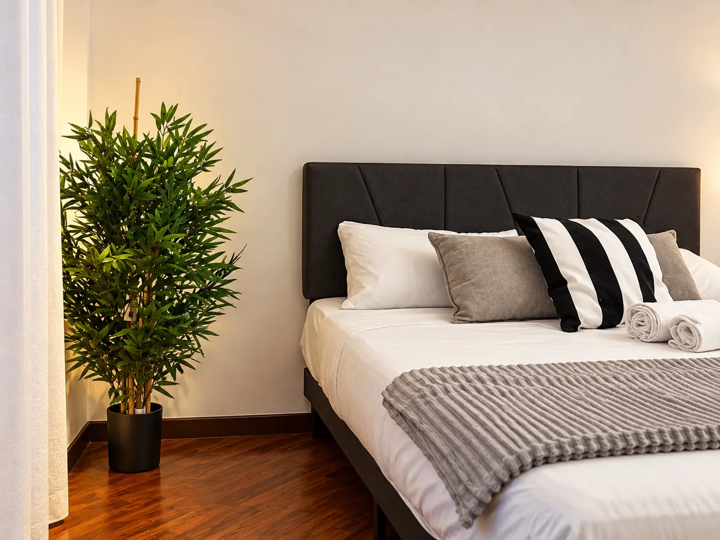 The Urban Ravanas bedroom with dark upholstered headboard