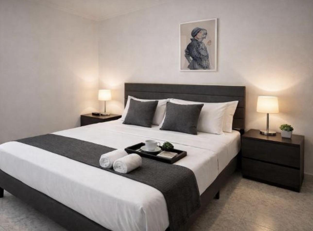 The Urban Lodge bedroom with dark bed and bedside lighting